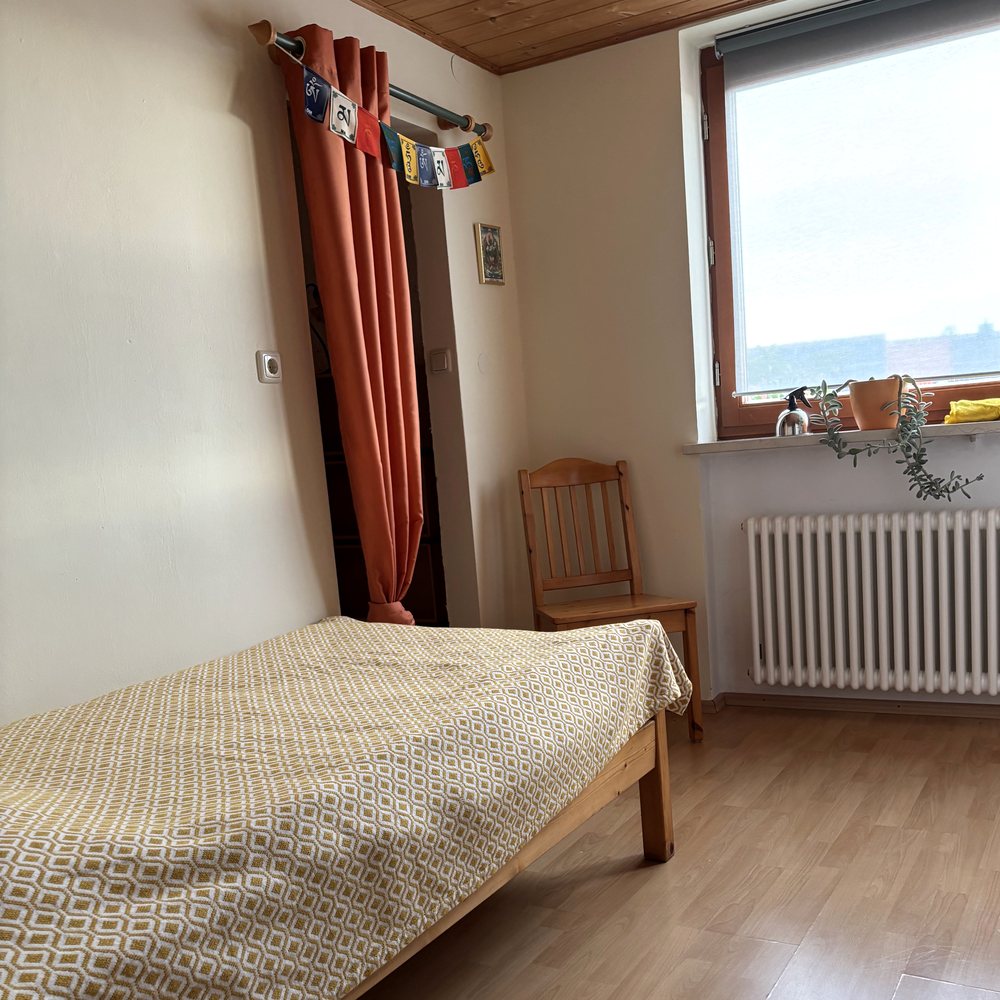 Helles Gästezimmer mit Fenster und Gebetsfahnen